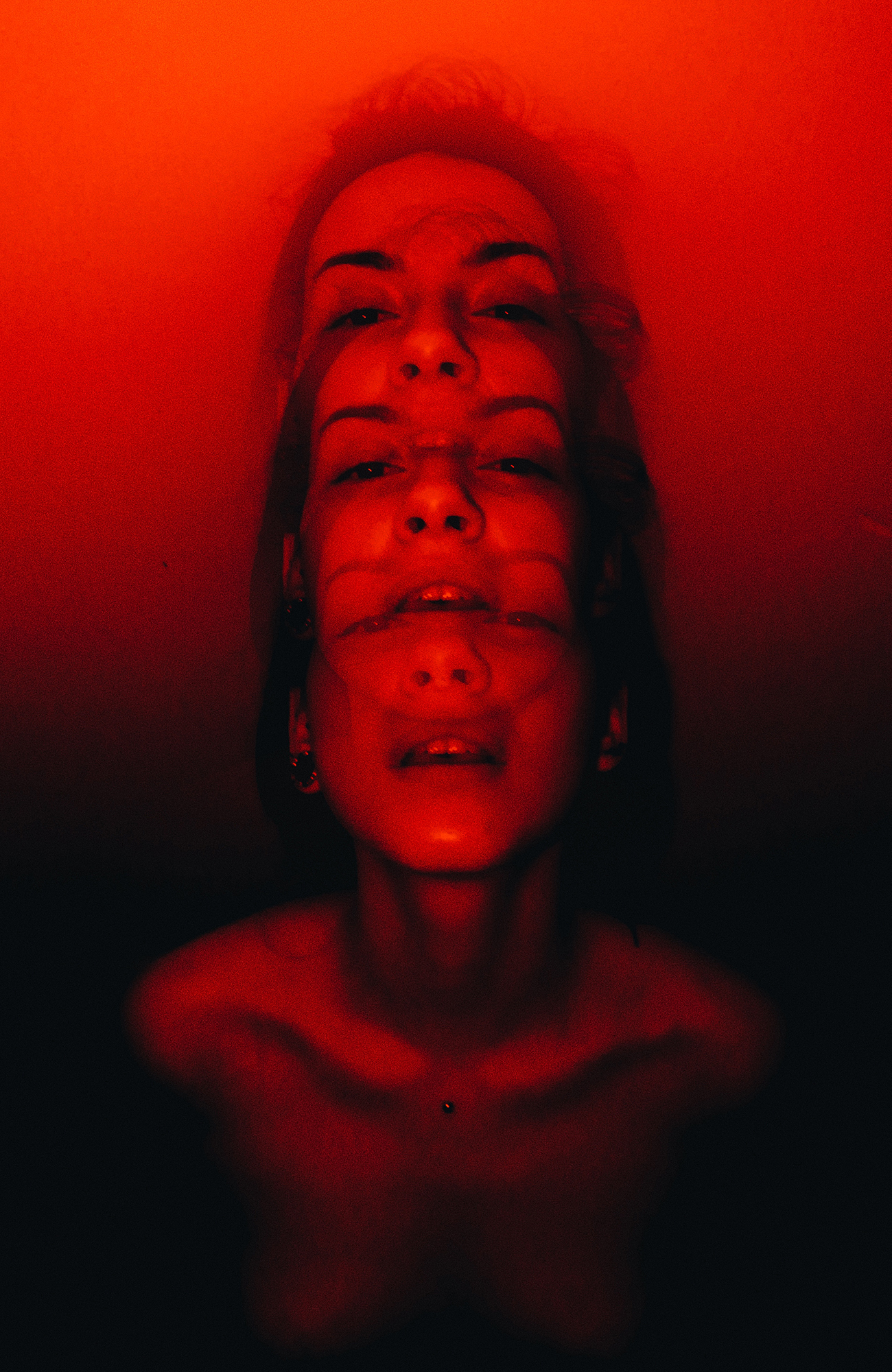 Nude woman’s head repeated three times in red-orange tones